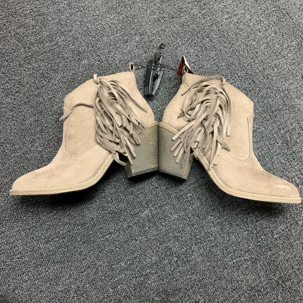 Taupe ankle booties with tassels.